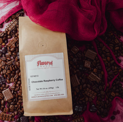 Bag of Chocolate Raspberry Coffee on a red background wtih coffee beans and pieces of chocolate