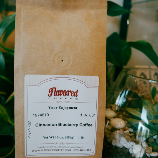 Coffee bag with a label reading 'Cinnamon Blueberry Coffee' against a natural background.