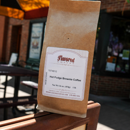 Brown paper bag with a label for Flavored Coffee on a wooden chair outdoors.