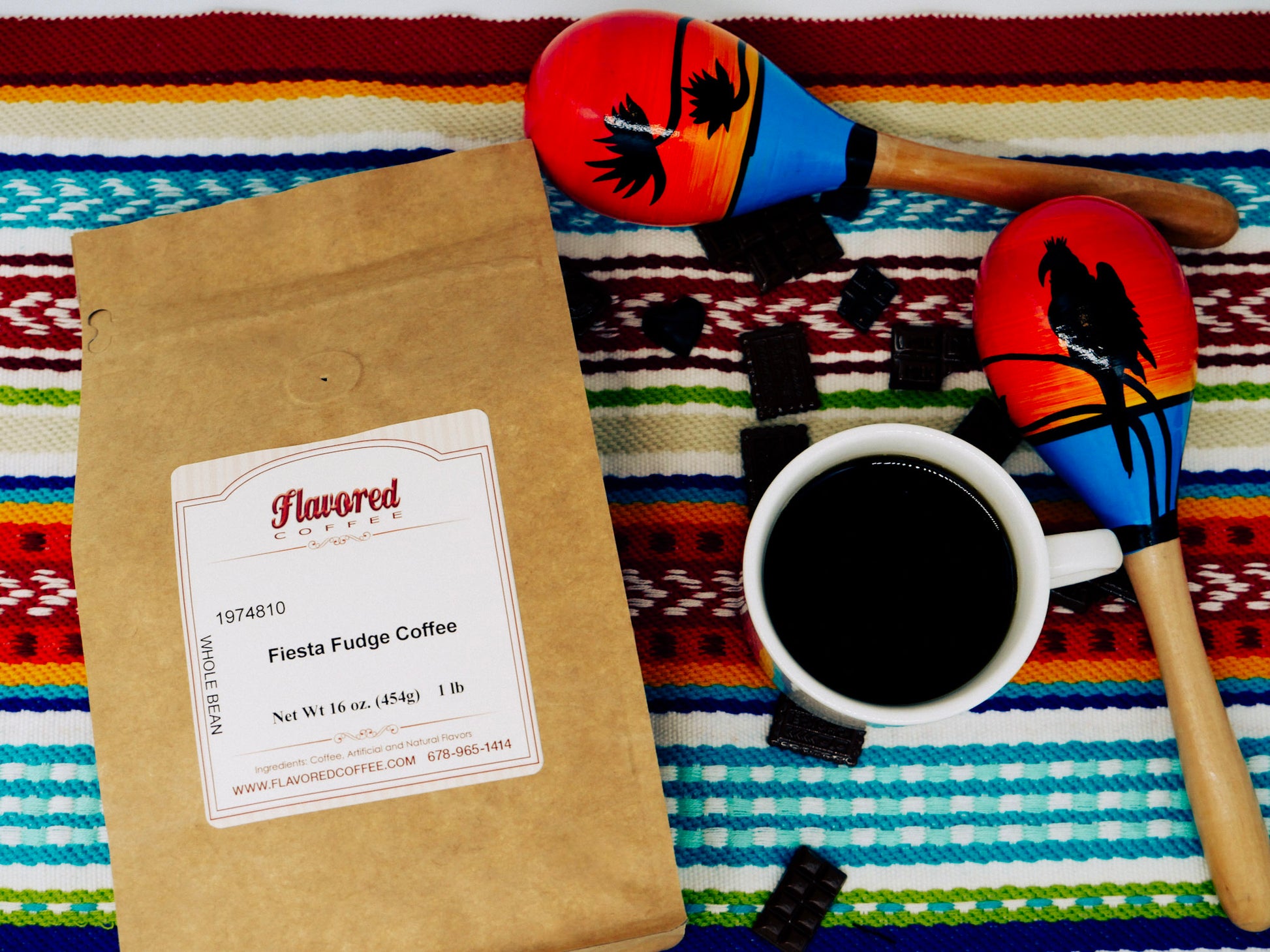 Flavored coffee package, cup of coffee, and maracas on a colorful patterned surface